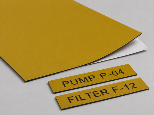 LYS-7039 muted yellow black core adhesive backed engraving sheet with release liner and shallow equipment ID samples
